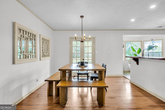 dining area with wood finished floors, visible vents, baseboards, and a notable chandelier