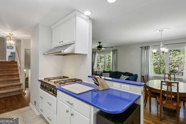 1649 Clairmont Way NE, Brookhaven, GA 30329 - kitchen with ceiling fan with notable chandelier, stainless steel gas cooktop, pendant lighting, white cabinets, and under cabinet range hood