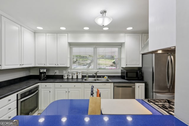 1649 Clairmont Way NE, Brookhaven, GA 30329 - kitchen featuring dark countertops, appliances with stainless steel finishes, a sink, and white cabinetry