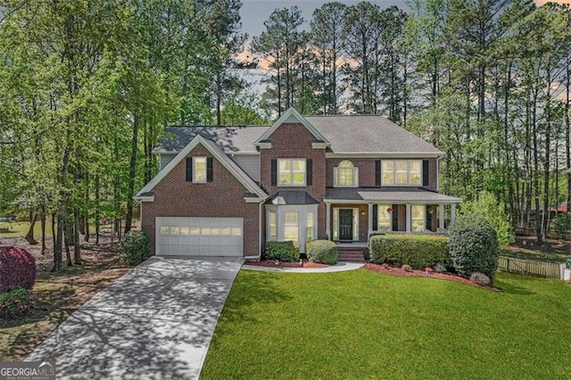 traditional home featuring a porch, brick siding, a front yard, and concrete driveway