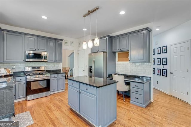 kitchen with stainless steel appliances, a center island, gray cabinetry, and decorative backsplash