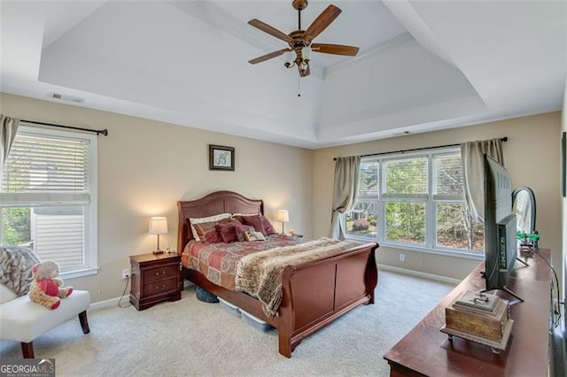 bedroom featuring baseboards, multiple windows, and a raised ceiling