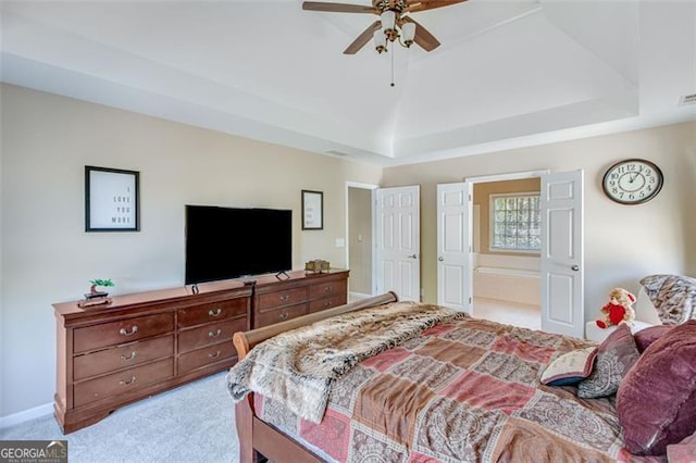 bedroom with light colored carpet, ceiling fan, baseboards, and a tray ceiling