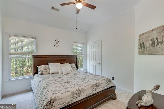 bedroom with vaulted ceiling, visible vents, baseboards, and light carpet