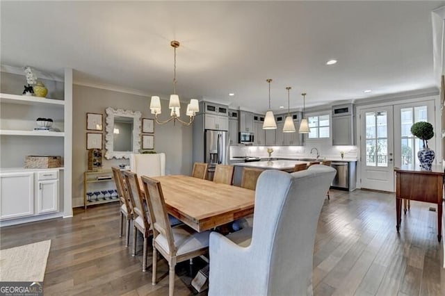 dining area with recessed lighting, a notable chandelier, ornamental molding, and dark wood finished floors