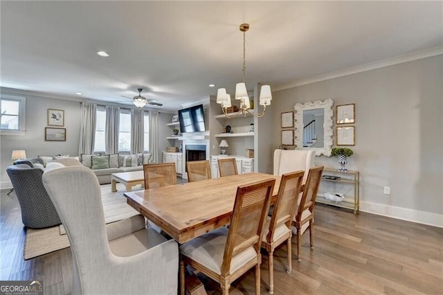 dining space featuring baseboards, wood finished floors, recessed lighting, and ornamental molding