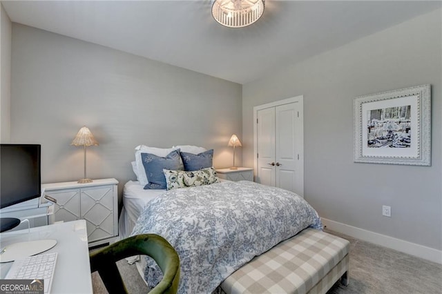 carpeted bedroom featuring a closet and baseboards
