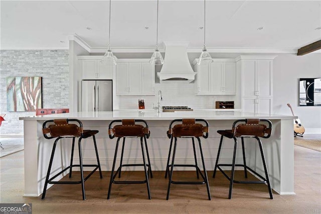 1268 Appleden Way Unit 17, Brookhaven, GA 30319 - kitchen featuring freestanding refrigerator, premium range hood, ornamental molding, a spacious island, and light countertops