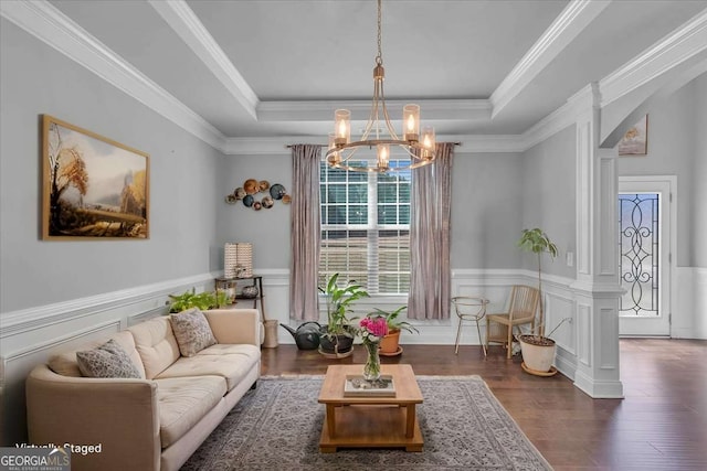 3206 Letha Woods Dr, Conyers, GA 30094 - living room with a raised ceiling, a chandelier, wainscoting, wood finished floors, and decorative columns