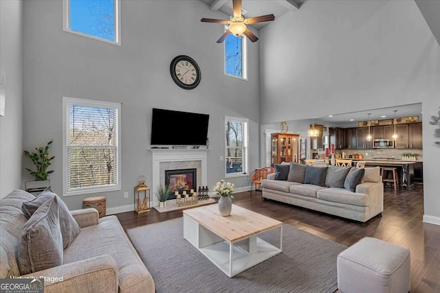 3206 Letha Woods Dr, Conyers, GA 30094 - living room with a high ceiling, plenty of natural light, a glass covered fireplace, dark wood-style flooring, and beam ceiling