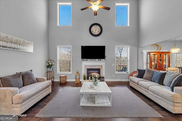 3206 Letha Woods Dr, Conyers, GA 30094 - living area featuring a high ceiling, ceiling fan, healthy amount of natural light, a glass covered fireplace, and dark wood finished floors