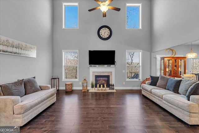 3206 Letha Woods Dr, Conyers, GA 30094 - living area featuring a towering ceiling, ceiling fan, plenty of natural light, a fireplace with flush hearth, and dark wood-style floors