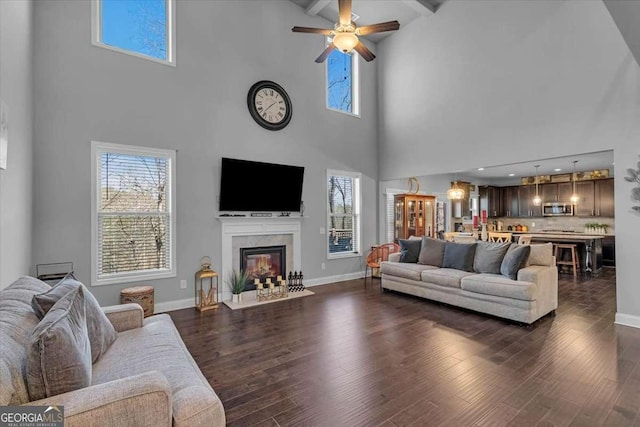 3206 Letha Woods Dr, Conyers, GA 30094 - living room with a high ceiling, a premium fireplace, dark wood-type flooring, a ceiling fan, and beam ceiling