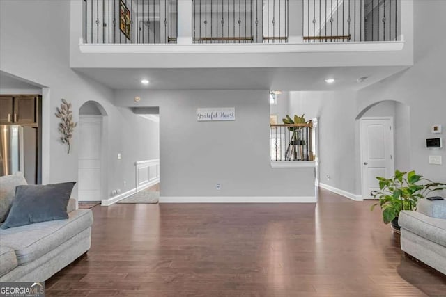 3206 Letha Woods Dr, Conyers, GA 30094 - living area featuring a towering ceiling, arched walkways, and wood finished floors