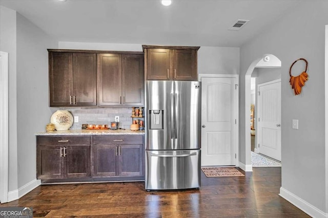 3206 Letha Woods Dr, Conyers, GA 30094 - kitchen with stainless steel refrigerator with ice dispenser, arched walkways, dark brown cabinets, and dark wood-type flooring