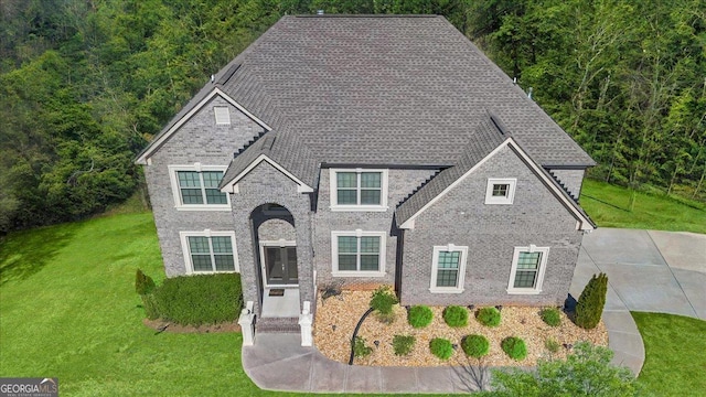 3206 Letha Woods Dr, Conyers, GA 30094 - view of front facade with a front yard, brick siding, and a forest view