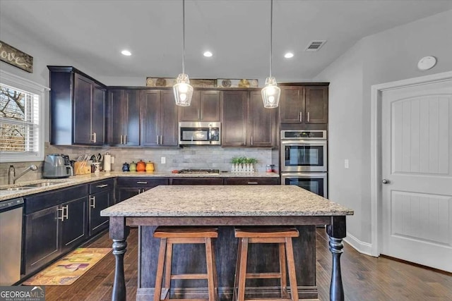 3206 Letha Woods Dr, Conyers, GA 30094 - kitchen featuring stainless steel appliances, dark wood-style floors, backsplash, a breakfast bar area, and recessed lighting