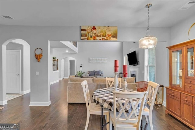 3206 Letha Woods Dr, Conyers, GA 30094 - dining room with arched walkways, dark wood-style flooring, and a fireplace