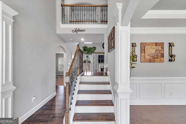 3206 Letha Woods Dr, Conyers, GA 30094 - stairs featuring arched walkways, wood finished floors, and crown molding