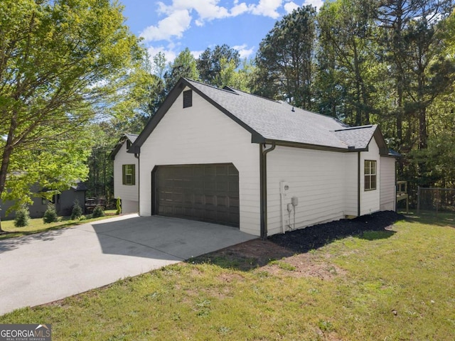 view of property exterior featuring an attached garage, a lawn, a shingled roof, and concrete driveway