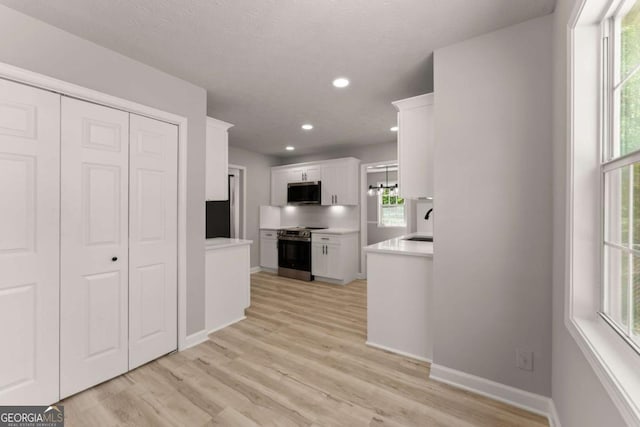 kitchen with white cabinets, a wealth of natural light, and stainless steel appliances