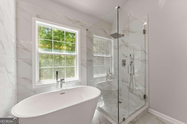 bathroom with a freestanding tub, marble finish floor, baseboards, and a marble finish shower