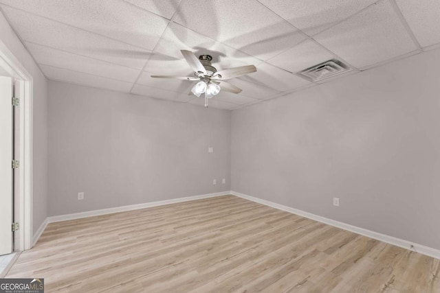 unfurnished room with visible vents, a ceiling fan, light wood-style floors, baseboards, and a paneled ceiling