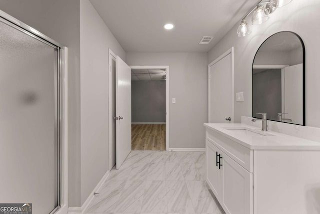 full bathroom with a shower stall, vanity, marble finish floor, baseboards, and visible vents