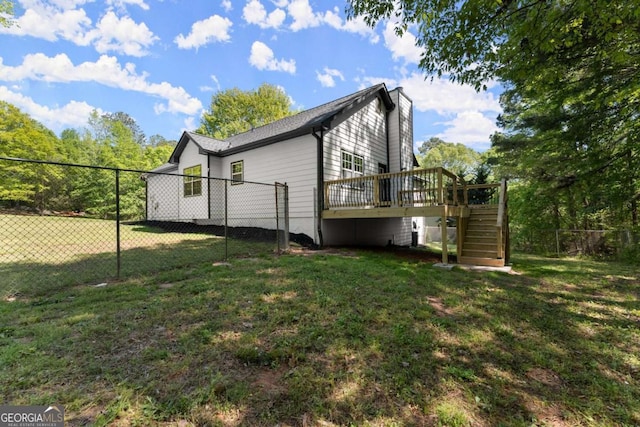 view of property exterior featuring fence, a yard, stairs, and a deck