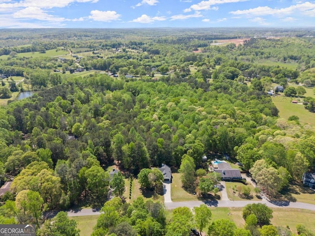 birds eye view of property featuring a wooded view