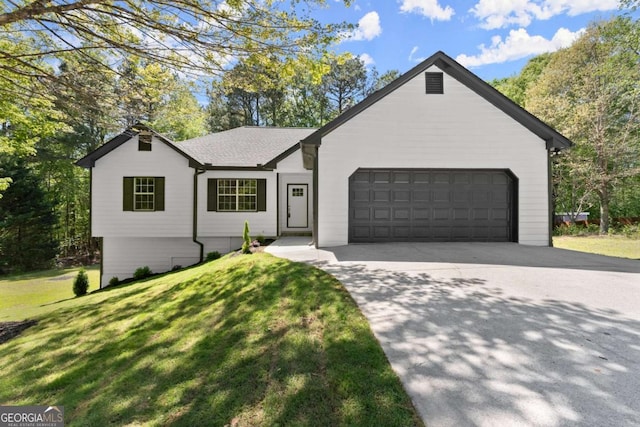 ranch-style home featuring concrete driveway, a front yard, and a garage