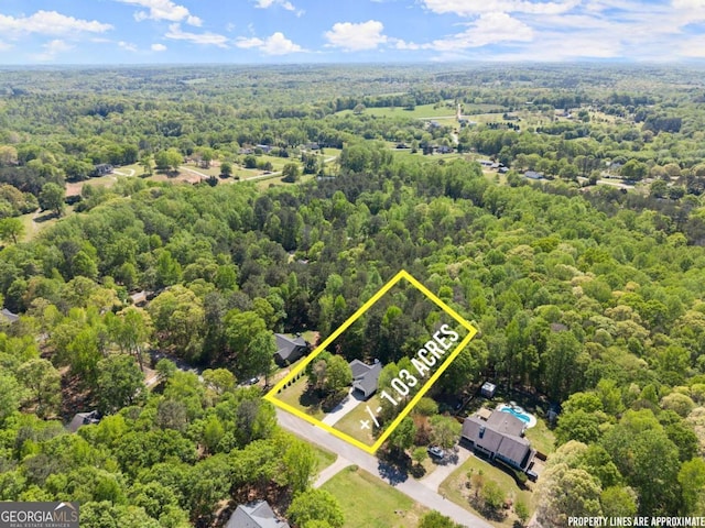 drone / aerial view featuring a wooded view