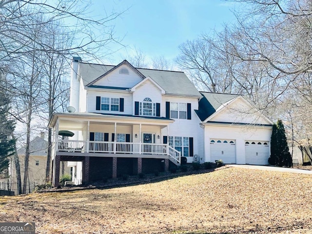 colonial house with an attached garage, a chimney, and covered porch