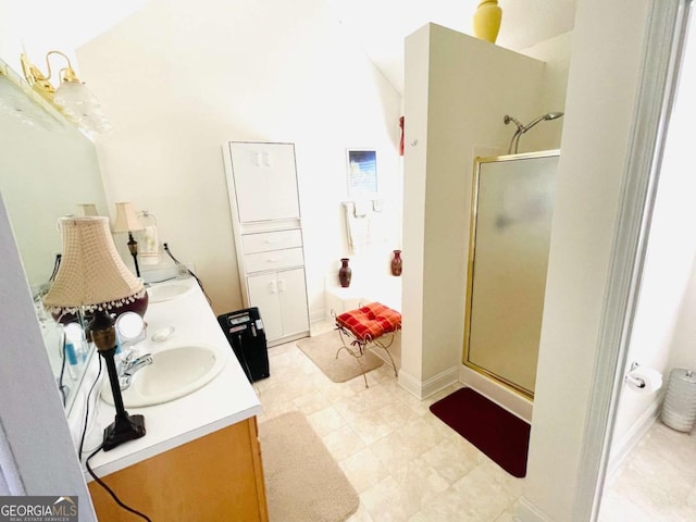 full bathroom with tile patterned floors, a sink, a stall shower, double vanity, and baseboards