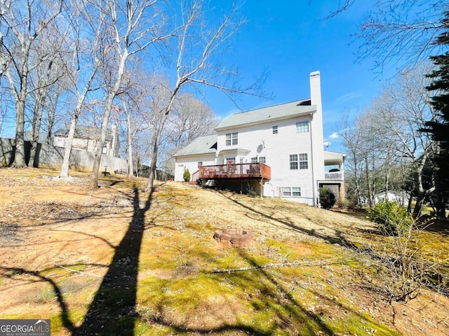 rear view of house with a chimney and a deck