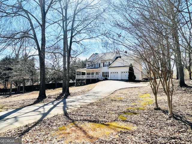 traditional-style house featuring an attached garage, driveway, and covered porch