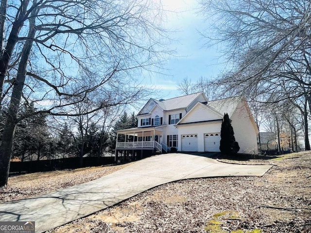 view of front of house featuring a garage, covered porch, and concrete driveway