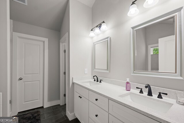 bathroom featuring tile patterned flooring, a sink, and double vanity