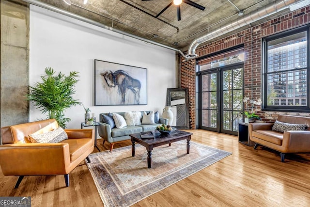 3180 Mathieson Dr NE Unit 703, Atlanta, GA 30305 - living area with wood finished floors, brick wall, ceiling fan, and a high ceiling