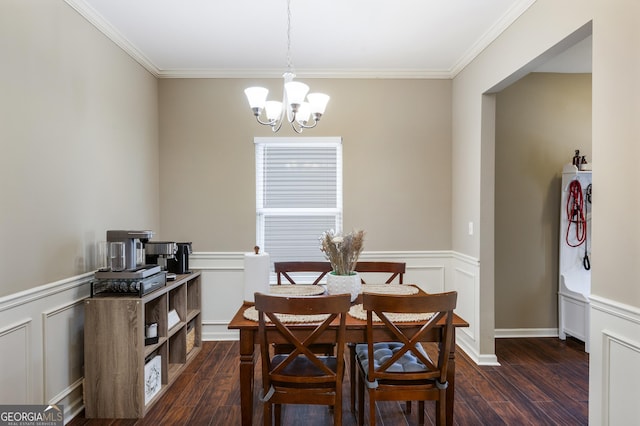 dining room with a decorative wall, crown molding, dark wood-style floors, and an inviting chandelier