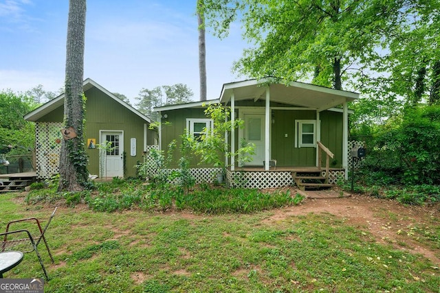 rear view of house with board and batten siding, covered porch, and a deck