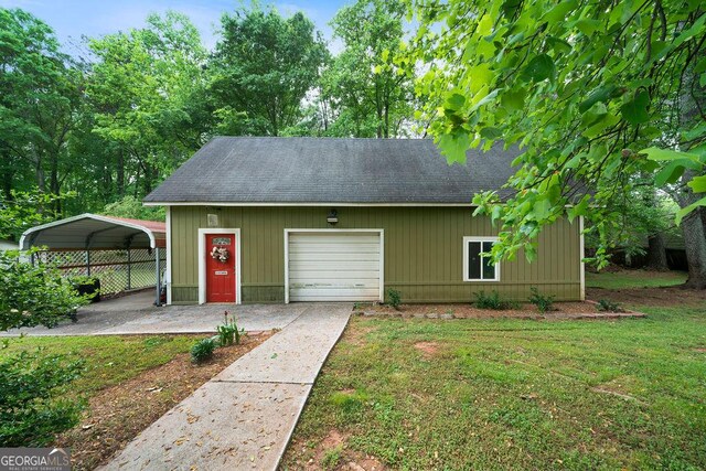 view of outbuilding featuring a garage, driveway, and a carport