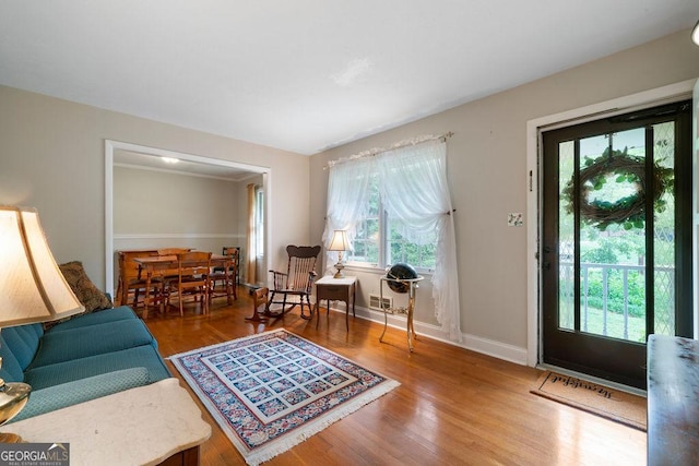 living area with baseboards and wood finished floors