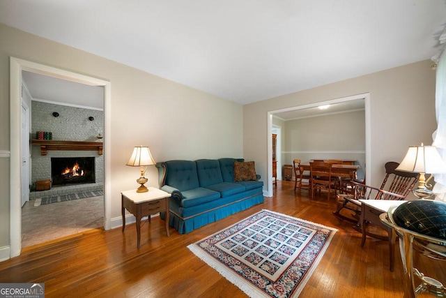 living room with wood finished floors and a brick fireplace