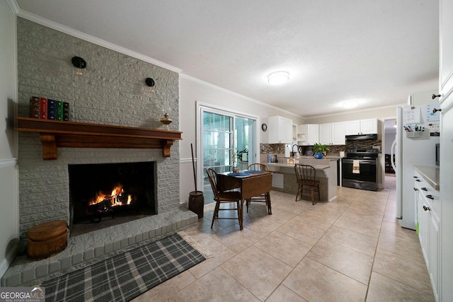 kitchen with under cabinet range hood, black range with electric cooktop, a peninsula, ornamental molding, and freestanding refrigerator