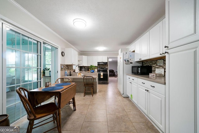 kitchen featuring decorative backsplash, black microwave, crown molding, and white cabinets