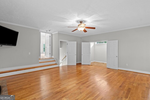 unfurnished living room featuring a ceiling fan, baseboards, ornamental molding, and light wood-type flooring