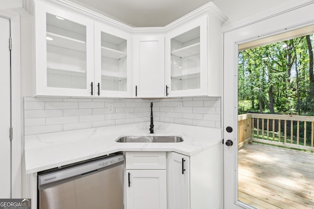 kitchen with decorative backsplash, stainless steel dishwasher, white cabinetry, and a sink