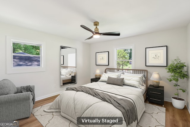 bedroom with wood finished floors, a ceiling fan, and baseboards