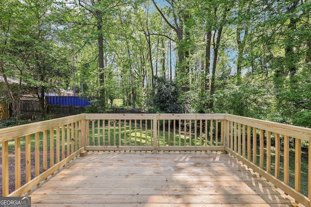 wooden terrace with a fenced backyard